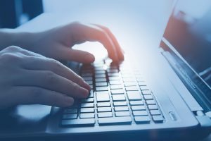 Male Hands On A Laptop Keyboard