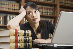 Asian woman leaning on stack of library books